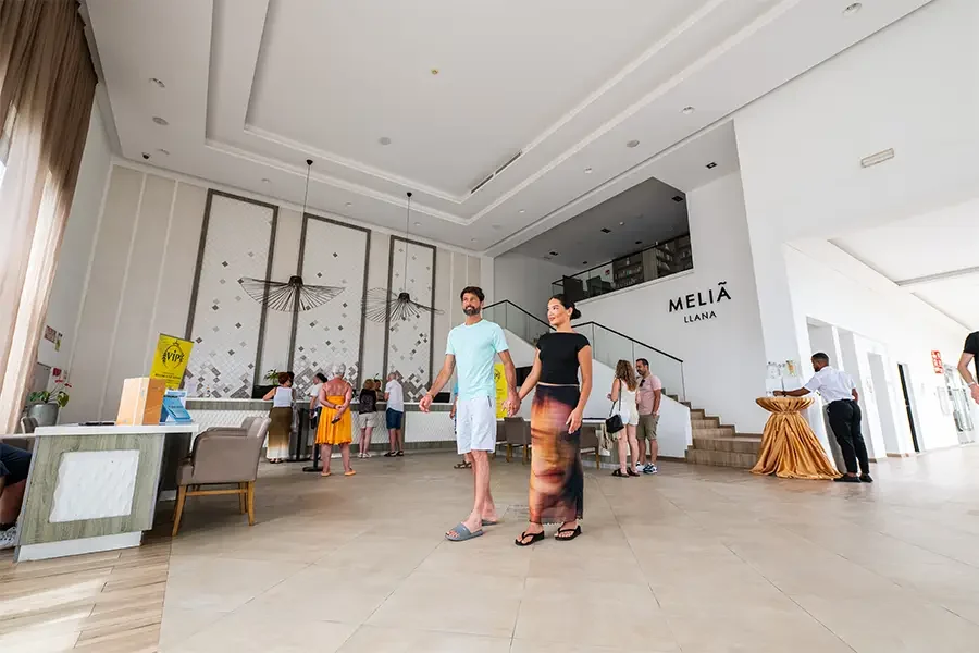 A couple walking inside the reception of Meliã Llana resort