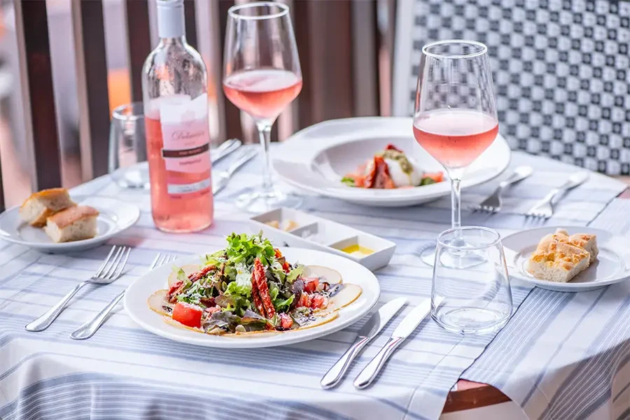 Food and rosé wine served on a table