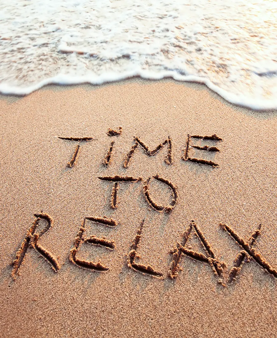 Time to relax written in the sand by the sea