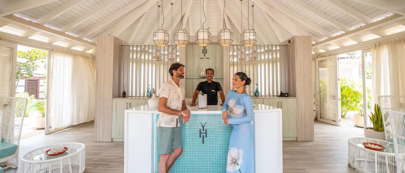 Um casal à entrada de uma estância termal