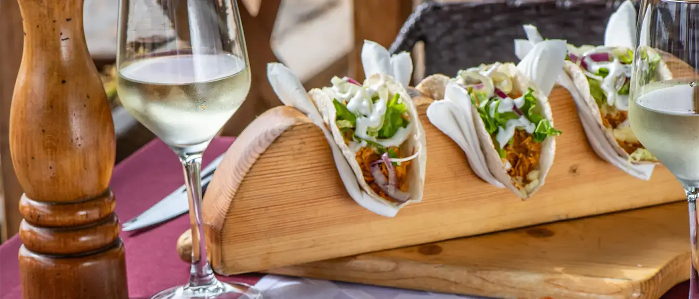 Close up of tacos and wine glasses